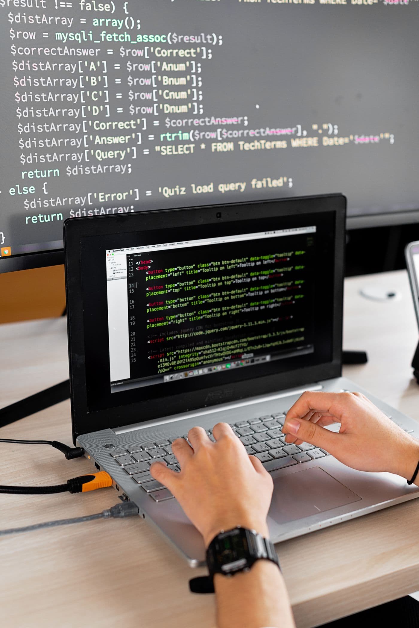 A developer working with a laptop and external monitor
